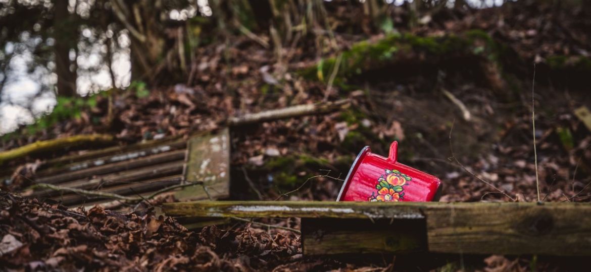 a small red box sitting on top of a pile of leaves